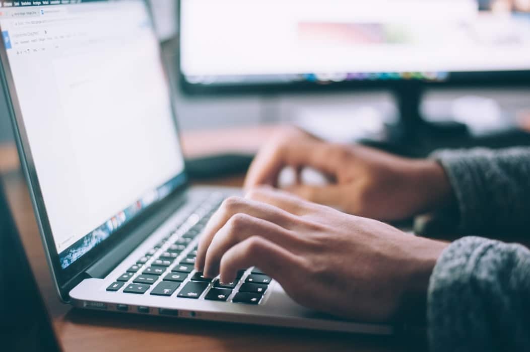 Man typt laptop vacatureteksten