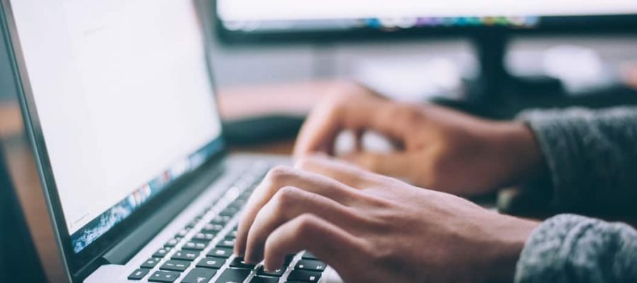 Man typt laptop vacatureteksten